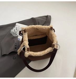 Detailed close-up of brown plush bucket bag with fuzzy cream sheepskin trim and silver ring