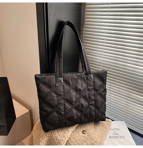 Detail of the black quilted nylon tote bag with rhombus patterns on a cozy background