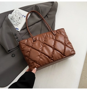 Brown quilted tote bag shown with grey blazer and magazine for a stylish office look
