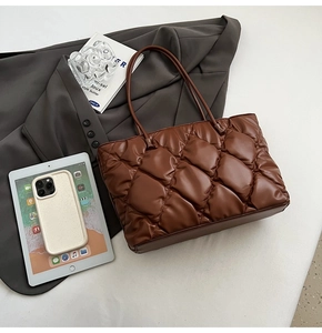 Detailed view of the dark brown quilted tote bag's matte leather texture and large diamond stitching