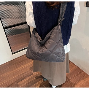 Detail of grey quilted nylon tote bag showing spacious design and padded texture