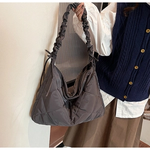 Close-up of charcoal grey quilted nylon bag with ruched shoulder strap and diamond pattern