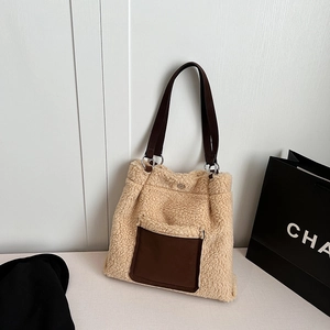 Close-up of fluffy beige faux shearling tote with brown leather pocket and metal rings