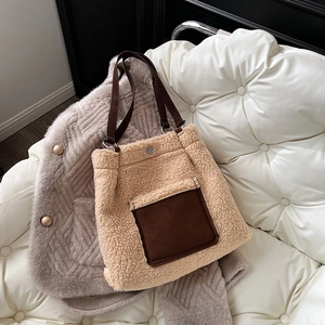 Close-up of beige shearling tote bag with brown faux leather pocket and shoulder strap