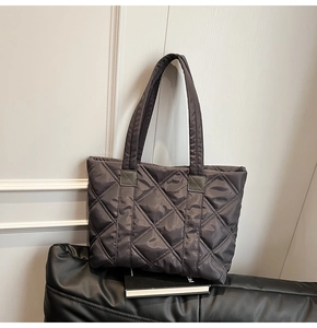 Macro detail of dark grey quilted tote bag showing rhombus stitching and nylon texture