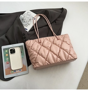 Detailed close-up of quilted diamond stitching on soft pink tote bag with shoulder straps