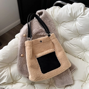 Detail of faux shearling tote bag with black leather straps on wool coat