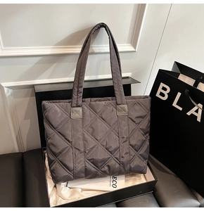 Borsa tote in nylon trapuntato grigio scuro in una scatola regalo con estetica di lusso