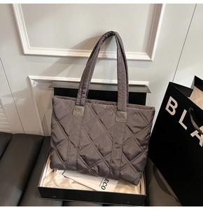 Detail of grey quilted nylon tote bag with rhombus stitching in a luxury gift box