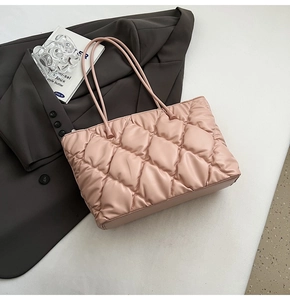 Detailed view of pink quilted tote bag with diamond pattern and slim shoulder straps
