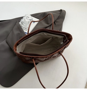 Interior view of quilted tote bag featuring light gray lining and secure zipper pocket