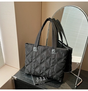 Close-up of quilted puffer tote bag with diamond stitching and reinforced handles