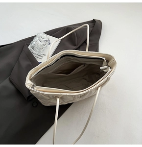 Top view of cream quilted tote bag showing spacious interior with zipper pocket and lining