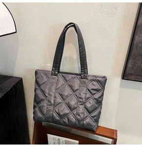 Detailed view of dark grey quilted nylon tote bag with diamond stitching and padded handles