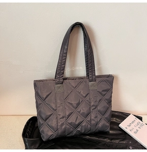 Close-up of dark grey quilted nylon tote bag with large diamond lattice stitching detail