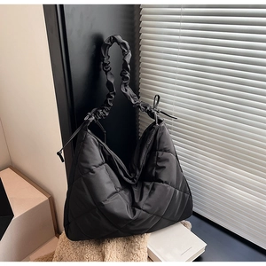 Detail of black quilted nylon bag with scrunchie strap and side drawstring ribbons