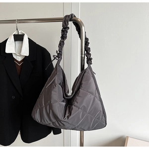 Detail view of dark grey quilted nylon tote bag with unique pleated cloud shoulder strap