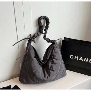 Close-up of dark grey quilted nylon fabric texture and ruched shoulder strap detail