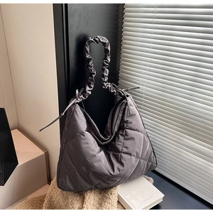 Close-up of charcoal grey quilted nylon tote with scrunchie strap and ribbon ties