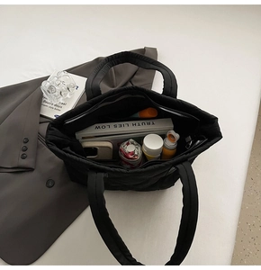 Top view of spacious black quilted tote bag interior with compartments for daily essentials