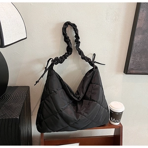 Detail of black quilted nylon tote bag with pleated cloud shoulder strap and side drawstrings