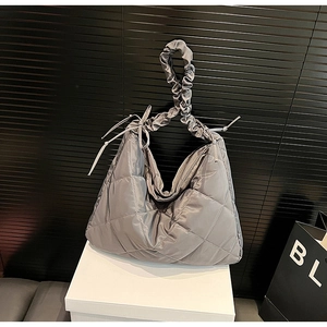 Detail of quilted nylon dumpling bag with pleated handle and metallic grey finish