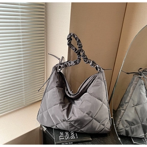 Detail of grey quilted nylon tote bag with unique ruched shoulder strap design
