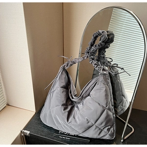 Macro shot of grey quilted nylon shoulder bag with elegant scrunchie style pleated strap