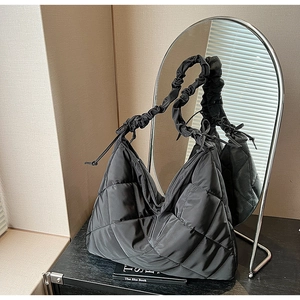 Detail of black quilted nylon hobo bag with large lattice pattern and ruched shoulder strap