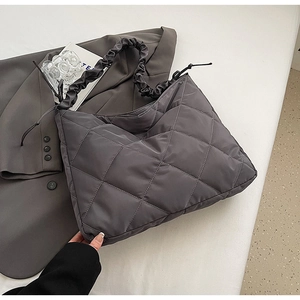 Close-up of quilted nylon dumpling bag with pleated strap and large capacity design