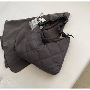 Close-up of dark grey quilted nylon tote bag featuring a unique scrunchie-style shoulder strap