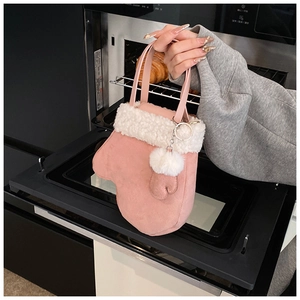 Detail of pink mitten-shaped handbag with white faux fur trim and plush pom-pom
