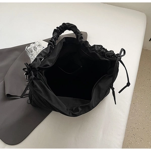 Internal view of black nylon tote bag showing spacious lining and zipper pocket detail