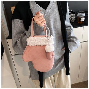 Detailed view of pink glove-shaped plush handbag with fuzzy white trim and faux fur pompom