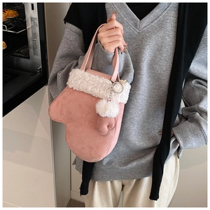 Pink suede glove-shaped handbag with white faux fur trim and fluffy ball charm detail