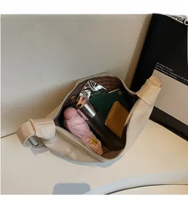 Spacious interior of beige dumpling bag showing storage for umbrella and essentials