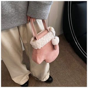 Detail of pink plush claw-shaped handbag with white faux fur trim and pompom pendant