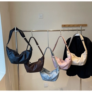 Five colors of pleated faux leather dumpling bags displayed on metal hangers