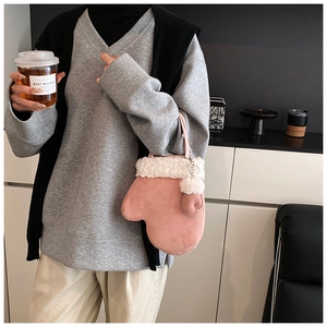 Detail of pink glove-shaped handbag with white plush trim and fuzzy pompom accessory