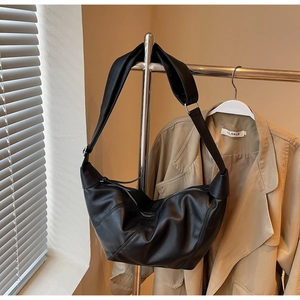 Detail shot of black matte leather crescent crossbody bag with adjustable wide shoulder strap