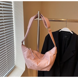 Detail of pink faux leather crescent bag with wide shoulder strap and metal zipper