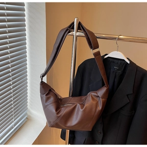 Detail of coffee brown moon bag showing diagonal stitching and premium matte leather texture