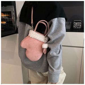 Pink glove-shaped crossbody bag with white faux fur trim and matching glove keychain detail