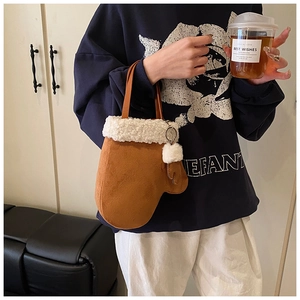 Detail of caramel suede glove-shaped handbag with plush trim and decorative pom-pom