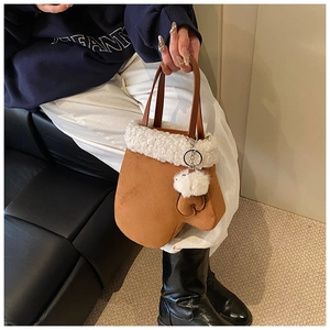 Detail of creative mitten-shaped handbag with brown suede and white faux fur trim