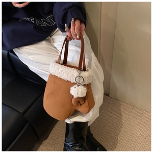 Detail of creative mitten-shaped bucket bag with plush trim and leather handle