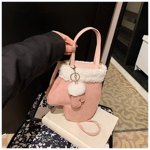 Detailed close-up of pink glove-shaped handbag with white faux fur trim and crossbody strap