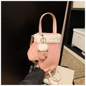 Close-up of pink mitten-shaped plush bucket bag with white faux fur trim and hand strap