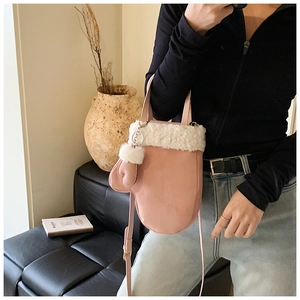Pink glove-shaped handbag with white faux fur trim and matching glove charm
