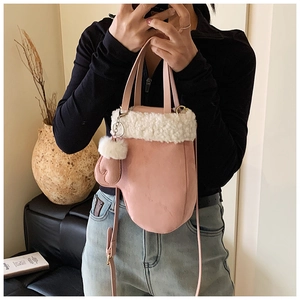 Pink glove-shaped handbag with white faux fur trim and matching mini glove pendant
